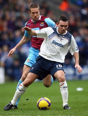 BOLTON, UNITED KINGDOM - FEBRUARY 21:  Mark Davies of Bolton Wanderers holds off a challenge from Matthew Upson of West Ham United during the Barclays Premier League match between Bolton Wanderers and West Ham United at the Reebok Stadium on February 21, 