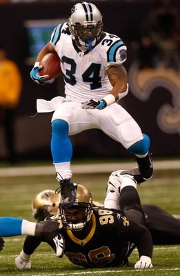 NEW ORLEANS - DECEMBER 28:  DeAngelo Williams #34 of the Carolina Panthers jumps over Sedrick Ellis #98 of the New Orleans Saints on December 28, 2008 at the Superdome in New Orleans, Louisiana.  (Photo by Chris Graythen/Getty Images)