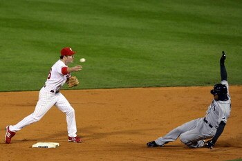 PHILADELPHIA - OCTOBER 29:  Chase Utley #26 of the Philadelphia Phillies turns a successful double play against a sliding Carl Crawford #13 of the Tampa Bay Rays on a ball hit by B.J. Upton #2 in the top of the eighth inning during the continuation of gam