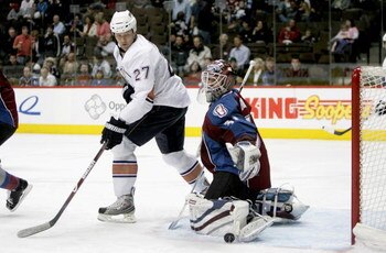 DENVER - MARCH 19:  Dustin Penner #27 of the Edmonton Oilers looks to redirect the puck as goaltender Peter Budaj #31 of the Colorado Avalanche makes a kick save during NHL action at the Pepsi Center on March 19, 2009 in Denver, Colorado.  (Photo by Doug 