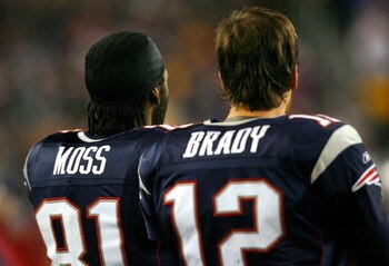 FOXBORO, MA - DECEMBER 23: Randy Moss #81 and Tom Brady #12 of the New England Patriots watch the defense in action against the Miami Dolphins at Gillette Stadium on December 23, 2007 in Foxboro, Massachusetts. Patriots won 28-7. (Photo by Jim Rogash/Gett
