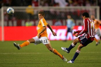 CARSON, CA - OCTOBER 20: Stuart Holden #22 of Houston Dynamo tries to get a foot on the ball as Orlando Perez #77 of CD Chivas USA clears the ball in the first half during their MLS match at the Home Depot Center October 20, 2007 in Carson, California.  (