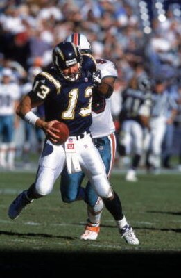 SAN DIEGO - NOVEMBER 12:  Quarterback Moses Moreno #13 of the San Diego Chargers scrambles as he is sacked by Jason Taylor #99 of the Miami Dolphins on November 12, 2000 at Qualcomm Stadium in San Diego, California.  The Dolphins defeated the Chargers 17-