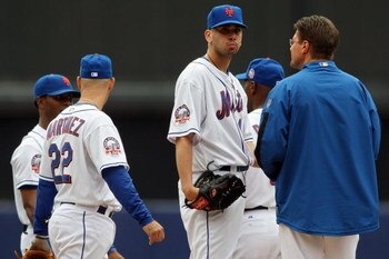 NEW YORK - SEPTEMBER 28:  Starting pitcher #46 Oliver Perez (center) of the New York Mets is visited by the trainer after feilding a hit with his pitching hand against the Florida Marlins during the last regular season baseball game ever played in Shea St