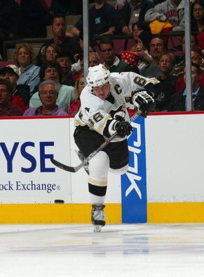 EAST RUTHERFORD, NJ - OCTOBER 5:  Mario Lemieux #66 of the Pittsburgh Penguins makes a pass from the blueline against the New Jersey Devils during their NHL opening night game at the Continental Airlines Arena on October 5, 2005 in East Rutherford, New Je