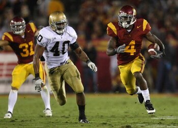 LOS ANGELES, CA - NOVEMBER 29:  Tailback Joe McKnight #4 of the USC Trojans is pursued by Maurice Crum #40 of the Notre Dame Fighting Irish during the game against at the Memorial Coliseum on November 29, 2008 in Los Angeles, California. USC defeated Notr