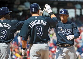 PHILADELPHIA - APRIL 4: First baseman Carlos Pena #23 of the Tampa Bay Rays gets congratulated by teammates left fielder Carl Crawford #13 and third baseman Evan Longoria #3 after hitting a 3 run home-run in the top of the first inning during the game aga
