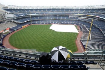 NEW YORK - APRIL 03:  Fans wait out the rain before the New York Yankees game against the Chicago Cubs at Yankee Stadium on April 3, 2009 in the Bronx borough of New York City.  (Photo by Ezra Shaw/Getty Images)
