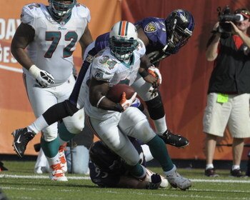 MIAMI, FL - JANUARY 4:  Running back Ricky Williams #34 of the Miami Dolphins rushes upfield against the Baltimore Ravens in an NFL Wildcard Playoff Game at Dolphins Stadium on January 4, 2009 in Miami, Florida.  (Photo by Al Messerschmidt/Getty Images) 