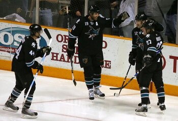 SAN JOSE, CA - DECEMBER 04:  (L-R) Marc-Edouard Vlasic #44, Joe Thornton #19, Patrick Marleau #12 of the San Jose Sharks congratulate teammate Jeremy Roenick #27 after Roenick scored a third period power play goal against the Columbus Blue Jackets during 
