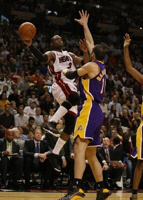 MIAMI - DECEMBER 19:  Dwyane Wade #3 of the Miami Heat passes around the defense of Vladimir Radmanovic #10 of the Los Angeles Lakers at American Airlines Arena on December 19, 2008 in Miami, Florida. The Heat defeated the Lakers 89-87. NOTE TO USER: User