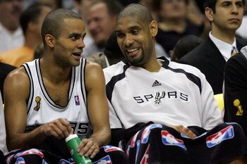 SAN ANTONIO - JUNE 10:  Tony Parker #9 and Tim Duncan #21 of the San Antonio Spurs smile on the bench as the Spurs lead the Cleveland Cavaliers in the second half of Game Two of the 2007 NBA Finals on June 10, 2007 at the AT&T Center in San Antonio, Texas