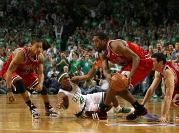BOSTON - APRIL 18:  John Salmons #15 of the Chicago Bulls nabs the loose ball from Rajon Rondo #9 of the Boston Celtics as Derrick Rose #1 of the Bulls defends in Game One of the Eastern Conference Quarterfinals during the 2009 NBA Playoffs at TD Banknort