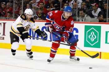 MONTREAL- APRIL 20:  Josh Gorges #26 of the Montreal Canadiens skates with the puck while being forechecked by Mark Recchi #28 of the Boston Bruins during Game Three of the Eastern Conference Quarterfinals of the 2009 Stanley Cup Playoffs at the Bell Cent