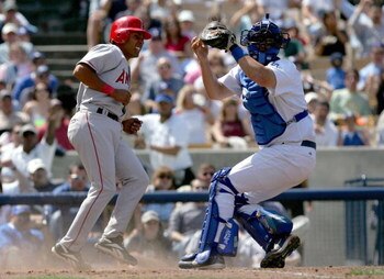 LOS ANGELES - APRIL 3:  Maicer Izturis #6 of the Los Angeles Angels of Anaheim is out at home plate by catcher Jason Phillips #17 of the Los Angeles Dodgers in the fifth inning of an exhibition game on April 3, 2004 at Dodger Stadium in Los Angeles, Calif