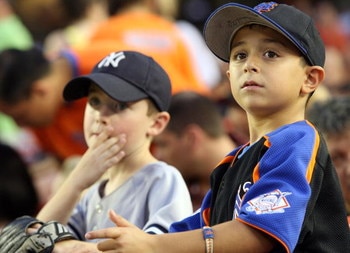 NEW YORK - JUNE 27: Young fans of the New York Yankees and the New York Mets watch at Shea Stadium on June 27, 2008 in the Flushing neighborhood of the Queens borough of New York City.  (Photo by Michael Heiman/Getty Images)