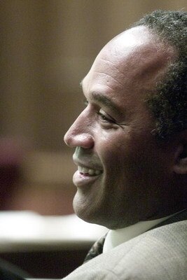 395698 07: Former NFL star O.J. Simpson talks to someone before the start of the third day of jury selection in a 'road rage' trial October 11, 2001 in Miami, FL. Simpson is on trial for allegedly attacking a Miami motorist December 4, 2000. If found guil
