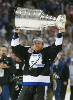TAMPA, FL - JUNE 7:   Brad Richards #19 of the Tampa Bay Lightning holds the Stanley Cup above his head after the victory over the Calgary Flames in Game seven of the NHL Stanley Cup Finals on June 7, 2004 at the St. Pete Times Forum in Tampa, Florida. Th