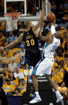 NEW ORLEANS - APRIL 25:  David West #30 of the New Orleans Hornets is met by  Dahntay Jones #30 of the Denver Nuggets as he drives to the basket in the fourt quarter in Game Three of the Western Conference Quarterfinals at New Orleans Arena on April 25, 2