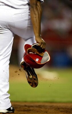 ANAHEIM, CA - AUGUST 24:  Jose Guillen #6 of the Anaheim Angels cleans out his cleats during their game against the Kansas City Royals on August 24, 2004 at Angel Stadium of Anaheim in Anaheim, California.  (Photo by Streeter Lecka/Getty Images)
