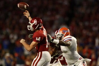 MIAMI - JANUARY 08:  Sam Bradford #14 of the Oklahoma Sooners gets pressured by Carlos Dunlap #8 of the Florida Gators as he throws during the FedEx BCS National Championship Game at Dolphin Stadium on January 8, 2009 in Miami, Florida.  (Photo by Donald 