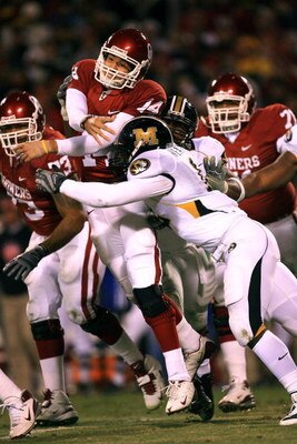 KANSAS CITY, MO - DECEMBER 06:  Quarterback Sam Bradford #14 of the Oklahoma Sooners is hit after releasing the ball during the first half of the game against the Missouri Tigers on December 6, 2008 at Arrowhead Stadium in Kansas City, Missouri.  (Photo b