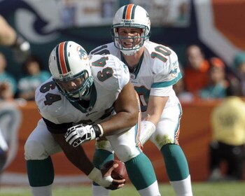MIAMI, FL - JANUARY 4:  Quarterback Chad Pennington #10 of the Miami Dolphins takes a snap from center Samson Satele #64 against the Baltimore Ravens in an NFL Wildcard Playoff Game at Dolphins Stadium on January 4, 2009 in Miami, Florida.  (Photo by Al M