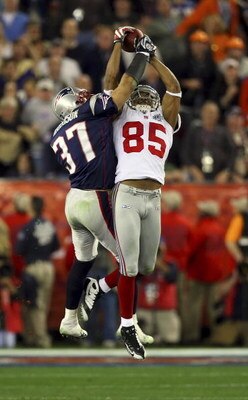 GLENDALE, AZ - FEBRUARY 03:  David Tyree #85 of the New York Giants catches a 32-yard pass from Eli Manning #10 as Rodney Harrison #37 of the New England Patriots attempts to knock it out in the fourth quarter of Super Bowl XLII on February 3, 2008 at the