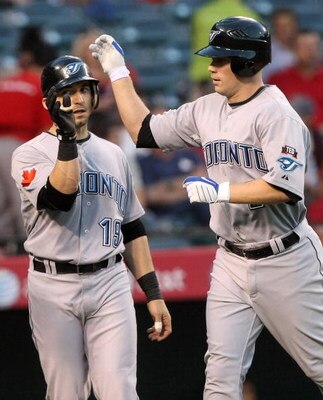 ANAHEIM, CA - MAY 6:  Aaron Hill #2 of the Toronto Blue Jays is greeted at home plate by Marco Scutaro #19 after both scored on Hill's first inning home run against the Los Angeles Angels of Anaheim at Angel Stadium May 6, 2009 in Anaheim, California.  (P