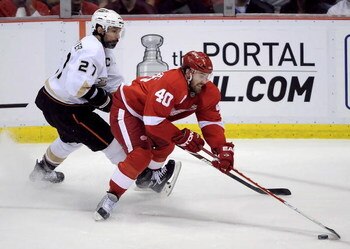 DETROIT - MAY 14:  Henrik Zetterberg #40 of the Detroit Red Wings tries to control the puck in front of Scott Niedermayer #27 of the Anaheim Ducks during Game Seven of the Western Conference Semifinals of the 2009 NHL Stanley Cup Playoffs on May 14, 2009 
