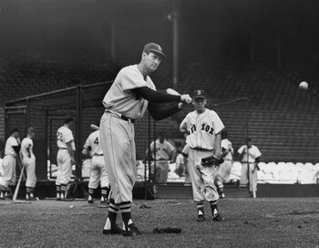 BOSTON, MA - CIRCA 1945:  (UNDATED FILE PHOTO)  Baseball legend Ted Williams (1918 - 2002) of the Boston Red Sox swings a bat at a ball during a pre-game practice as Walter 'Smokey' Baker, the 13-year-old son of Red Sox pitching coach Del Baker (1892 - 19