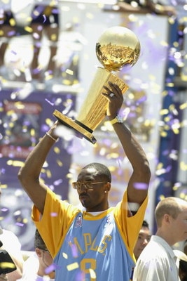 LOS ANGELES - JUNE 14: Kobe Bryant #8 of the Los Angeles Lakers holds up the Larry O'Brien trophy on stage in downtown Los Angeles following the victory parade on June 14, 2002 at Staples Center in Los Angeles, California.  The Lakers won their third cons