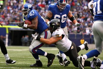 EAST RUTHERFORD, NJ - NOVEMBER 16:  Brandon Jacobs #27 of the New York Giants runs the ball as Justin Bannan #94 of the Baltimore Ravens defends during their game on November 16, 2008 at Giants Stadium in East Rutherford, New Jersey.  (Photo by Al Bello/G
