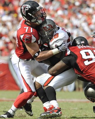 TAMPA, FL - SEPTEMBER 14: Defensive tackle Jonathan Babineaux #95 and defensive end Kroy Biermann #71 of the Atlanta Falcons stop running back Warrick Dunn #28 of the Tampa Bay Buccaneers at Raymond James Stadium on September 14, 2008 in Tampa, Florida.  