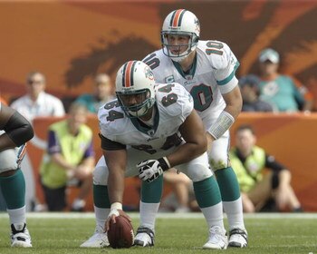 MIAMI, FL - JANUARY 4:  Quarterback Chad Pennington #10 of the Miami Dolphins takes a snap from center Samson Satele #64 against the Baltimore Ravens in an NFL Wildcard Playoff Game at Dolphins Stadium on January 4, 2009 in Miami, Florida.  (Photo by Al M