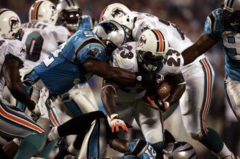 CHARLOTTE, NC - AUGUST 24:  Running back Ronnie Brown #23 of the Miami Dolphins is tackled by the Carolina Panthers during the preseason game at Bank of America Stadium in Charlotte, North Carolina, on August 24, 2006. The Panthers won 19-10.  (Photo by D