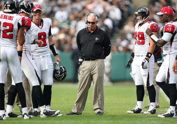 OAKLAND, CA - NOVEMBER 2:  Head Coach Mike Smith of the Atlanta Falcons stands on the field in the midst of his players wearing his radio headset during a break in the game against the Oakland Raiders on November 2, 2008 at the Oakland-Alameda County Coli