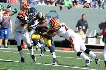 EAST RUTHERFORD, NJ - OCTOBER 12:  Jerricho Cotchery #89 of the New York Jets makes a catch as David Jones #20 and Marvin White #26 of the Cincinnati Bengals make the tackle during their game on October 12, 2008 at Giants Stadium in East Rutherford, New J