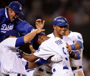 LOS ANGELES, CA - MAY 23:  Juan Pierre #9 (C) of the Los Angeles Dodgers is congratulated by pitcher Clayton Kershaw (L) catcher Russell Martin (2L) and Matt Kemp #27 who scored the winning run after a bases loaded walk to Pierre to defeat the Los Angeles