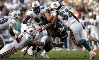 SAN DIEGO - DECEMBER 11:  Running back LaDainian Tomlinson #21 of the San Diego Chargers is tackeld by Zach Thomas #54 and Channing Crowder #52 of the Miami Dolphins during the Chargers 23-21 loss to the Dolphins during the 2nd half of their NFL Game on D
