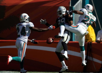 MIAMI - NOVEMBER 16:  Receiver Ronald Curry #89 of the Oakland Raiders is defended by safety Will Allen #25 and Renaldo Hill #24 of the Miami Dolphins in the second quarter at Dolphin Stadium November 16, 2008 in Miami, Florida. Miami defeated Oakland 17-