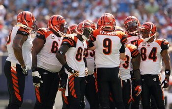 EAST RUTHERFORD, NJ - SEPTEMBER 21:  Carson Palmer #9  of the Cincinnati Bengals talks in the huddle as teammates Chad 'Ocho Cinco' Johnson #85 and T.J. Houshmandzadeh #84 listen during the first half of the game against the New York Giants on September 2
