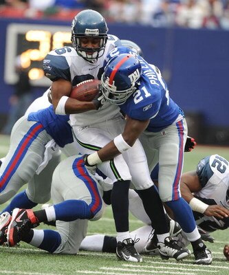 EAST RUTHERFORD, NJ - OCTOBER 05:  Kenny Phillips #21 of the New York Giants tackles Josh Wilson #26of the Seattle Seahawks during their game on October 5, 2008 at Giants Stadium in East Rutherford, New Jersey.  (Photo by Al Bello/Getty Images)