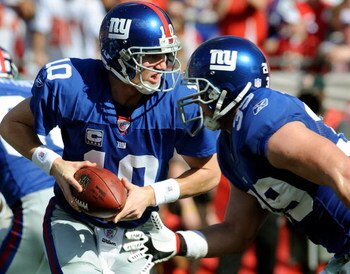 TAMPA, FL - JANUARY 06:  Quarterback Eli Manning #10 of the New York Giants looks to pass the ball behind teammate Madison Hedgecock #39 during the second quarter of the NFC Wild Card game against Tampa Bay Buccaneers at Raymond James Stadium on January 6
