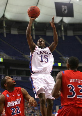 MINNEAPOLIS - MARCH 22: Tyshawn Taylor #15 of the Kansas Jayhawks drives for a shot attempt in the first half against Paul Wlliams #22 and Chris Wright #33 of the Dayton Flyers during the second round of the NCAA Division I Men's Basketball Tournament at