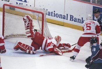 26 May 1997: Goaltender Mike Vernon and defenseman Niklaus Lidstrom of the Detroit Red wings take care of the puck as right wing Scott Young of the Colorado Avalanche gives chase during a playoff game at Joe Louis Arena in Detroit, Michigan. The Red Wings