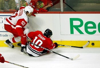 CHICAGO - MAY 24:  Patrick Sharp #10 of the Chicago Blackhawks reaches for the puck against Jonathan Ericsson #52 of the Detroit Red Wings during Game Four of the Western Conference Championship Round of the 2009 Stanley Cup Playoffs on May 24, 2009 at th