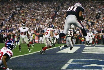 GLENDALE, AZ - FEBRUARY 03:  Wide receiver Randy Moss #81 of the New England Patriots catches a six-yard touchdown pass from Tom Brady #12 in front of cornerback Corey Webster #23 of the New York Giants in the fourth quarter of Super Bowl XLII on February