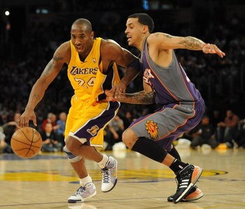 LOS ANGELES, CA - DECEMBER 10:  Kobe Bryant #24  of the Los Angeles Lakers dribbles around Matt Barnes #22 of the Phoenix Suns during the second half at the Staples Center on December, 10 2008 in Los Angeles, California.   NOTE TO USER: User expressly ack