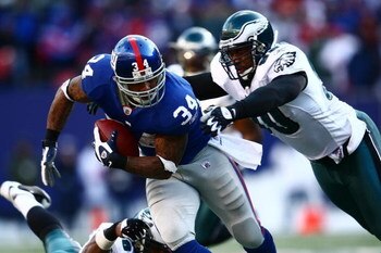 EAST RUTHERFORD, NJ - JANUARY 11: Derrick Ward #34 of the New York Giants runs against Darren Howard #90 of the Philadelphia Eagles during the NFC Divisional Playoff Game on January 11, 2009 at Giants Stadium in East Rutherford, New Jersey.  (Photo by Chr